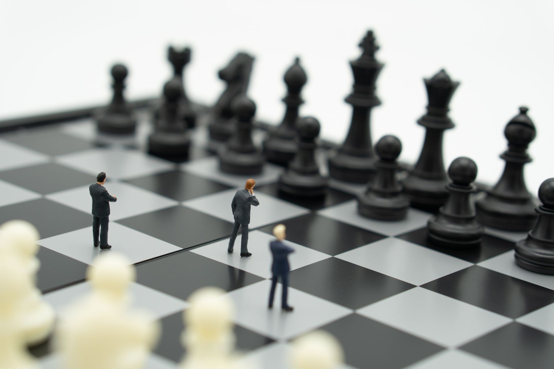 Miniature people businessmen standing Chess Analysis Communicate about business strategy. Or business planning using as background business concept and Strategy concept with copy space for your text.
